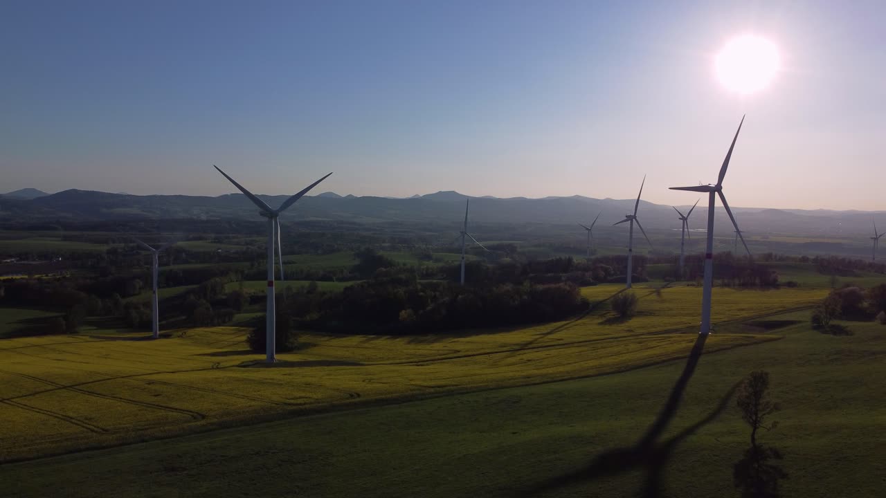 Group of windmills on meadow, spring colors before sunset, drone static view