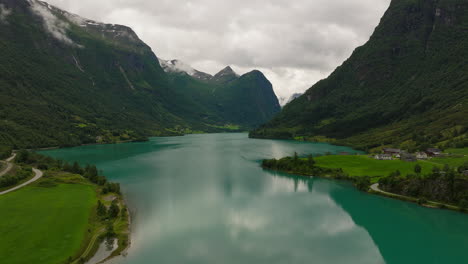 Un-Paisaje-Idílico-De-Un-Lago-De-Aguas-Tranquilas-De-Color-Turquesa-Y-Un-Paisaje-Montañoso.