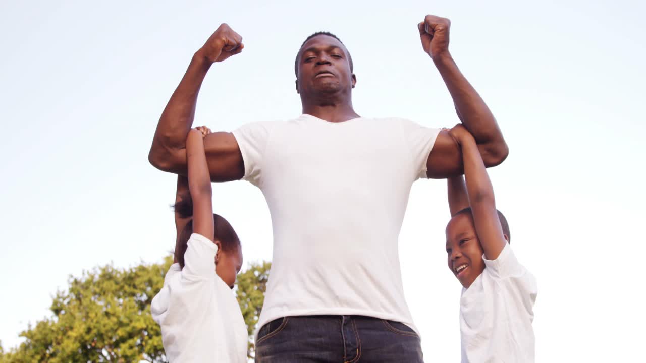 Muscled man holding his children