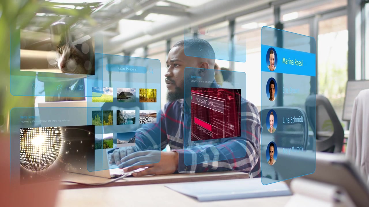 Man typing, glancing right, causing holo panels around him cycling DNA, map, clock for tech work