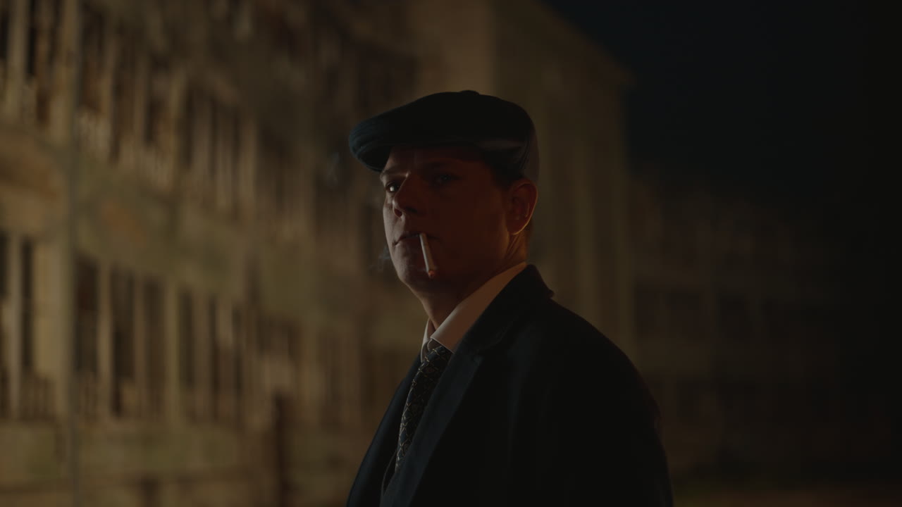 Man in hat smoking at night