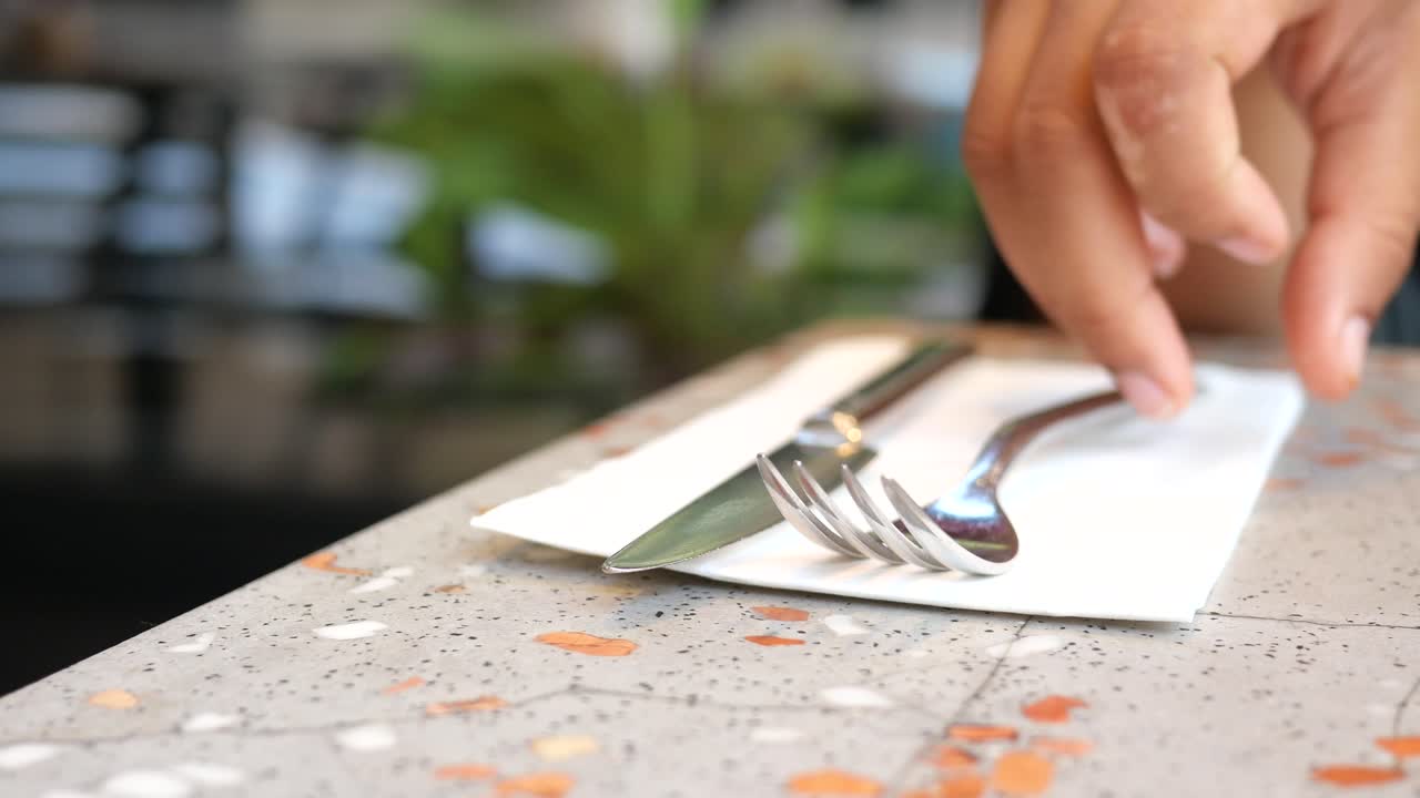 한 사람 의 손 이 테이블 에 있는 포크 와 칼 을 잡는다