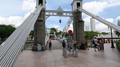 people walking under an ornate archway in a park.