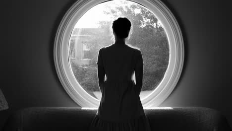 woman looking out round window