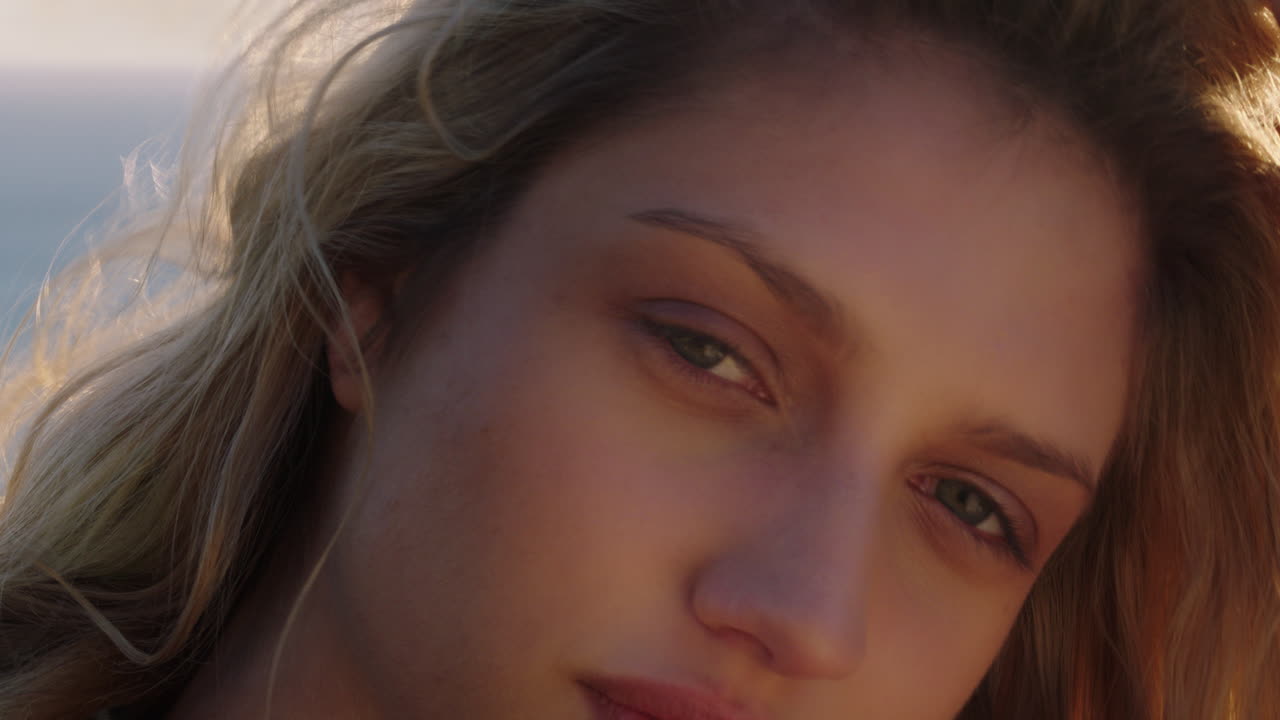 행복 한 여자 의 초상화 가 웃고 여름 휴가 에 재미 를 즐기고 바람 이 날아다니는 머리카락 과 함께 해 가 지는 것 을 즐기고 있다