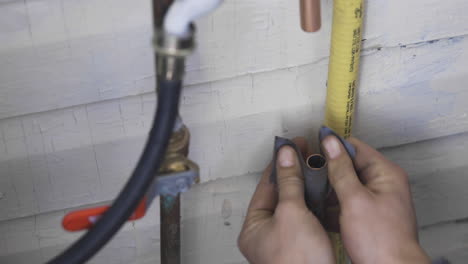 Cleaning-a-dirty-copper-pipe-with-sand-paper-to-prepare-it-for-soldering