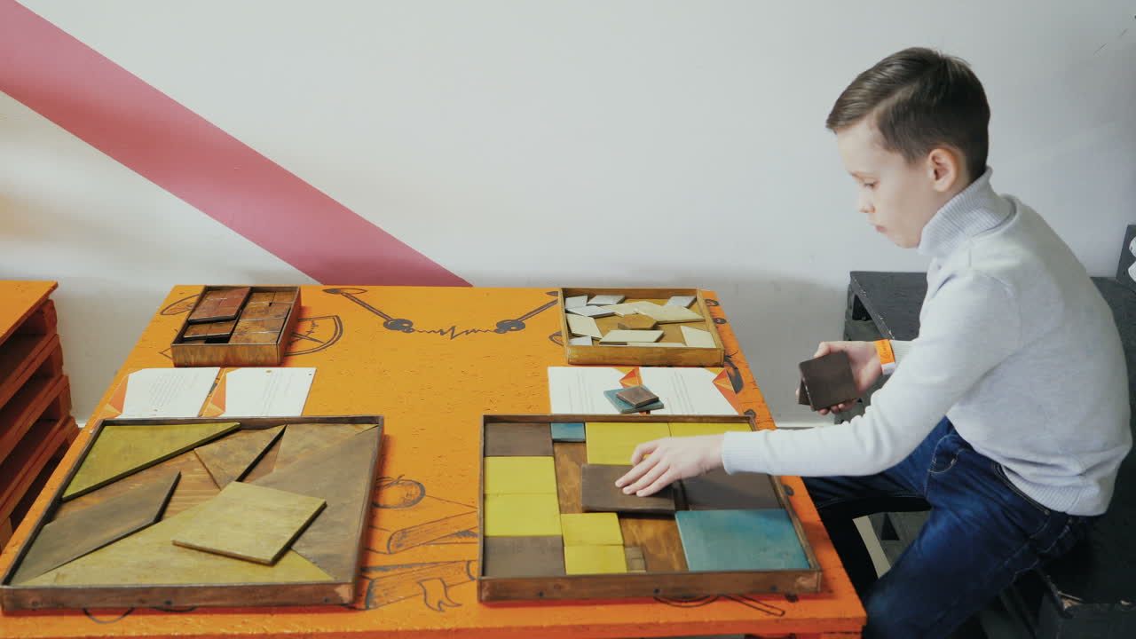 Boy playing with puzzle wooden tangram. Early education concept