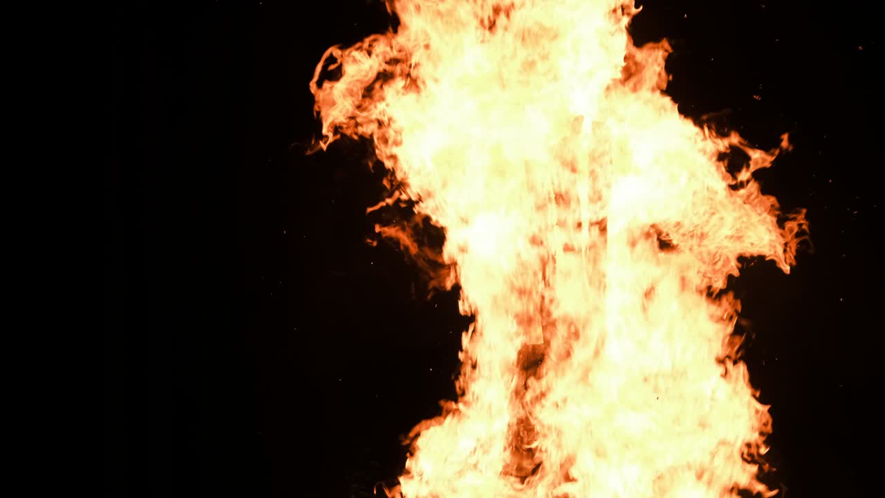 una gran hoguera arde por la noche en cámara lenta sobre un fondo negro en la naturaleza