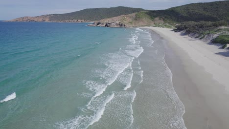 澳洲昆士蘭大凱佩爾島 (great keppel island, queensland) 的沉船海灘 (wreck beach) 的海浪在海岸上<unk>水 - - 從空中撤回