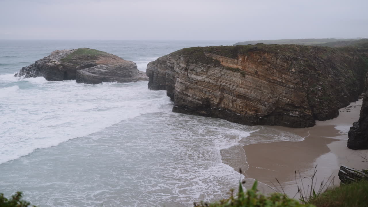 Overcast Coastal Landscape with Rock Formations and Waves