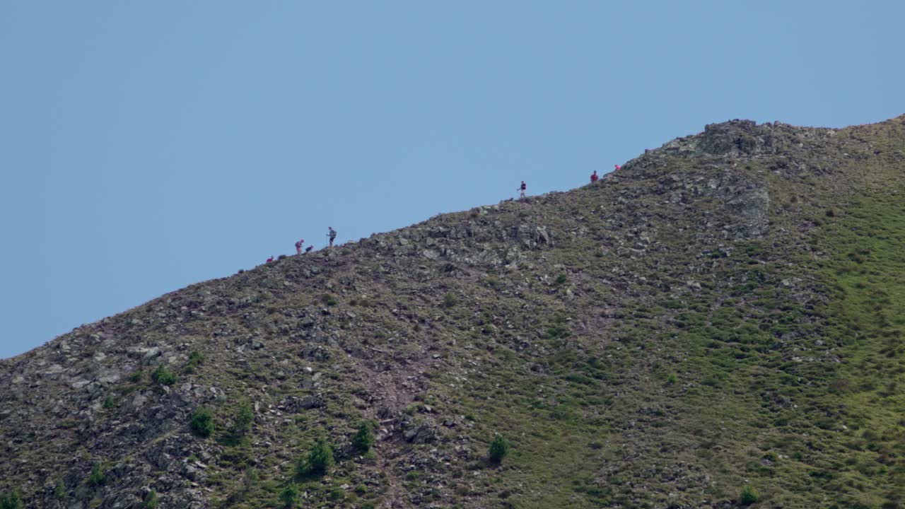 Hikers walking along a trail near the summit of Mount Schwarzhorn - Corno Nero, South Tyrol, Italy