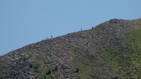 hikers walking along a trail near the summit of mount schwarzhorn - corno nero, south tyrol, italy