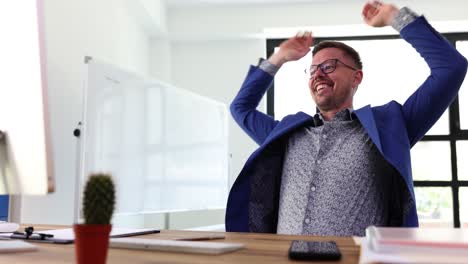 happy businessman celebrating success at office desk