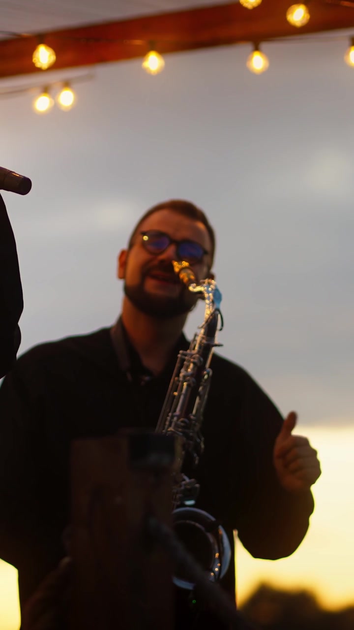 Esibizione di musica dal vivo con sassofonista e cantante al tramonto