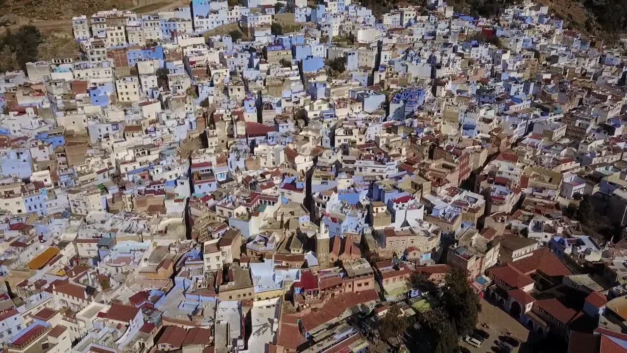 Incredible HD wide aerial view of the iconic blue-washed buildings in Chefchaouen medina. Captures the dense urban texture and unique architecture of Morocco's Blue City. Great for travel and heritage