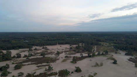 Aerial-of-beautiful-sand-dunes-against-a-bright,-cloudy-sky