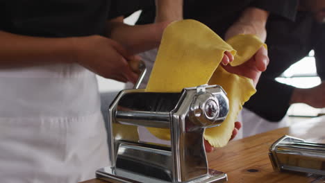 Diverse-group-of-chefs-preparing-dishes-and-smiling-in-a-kitchen