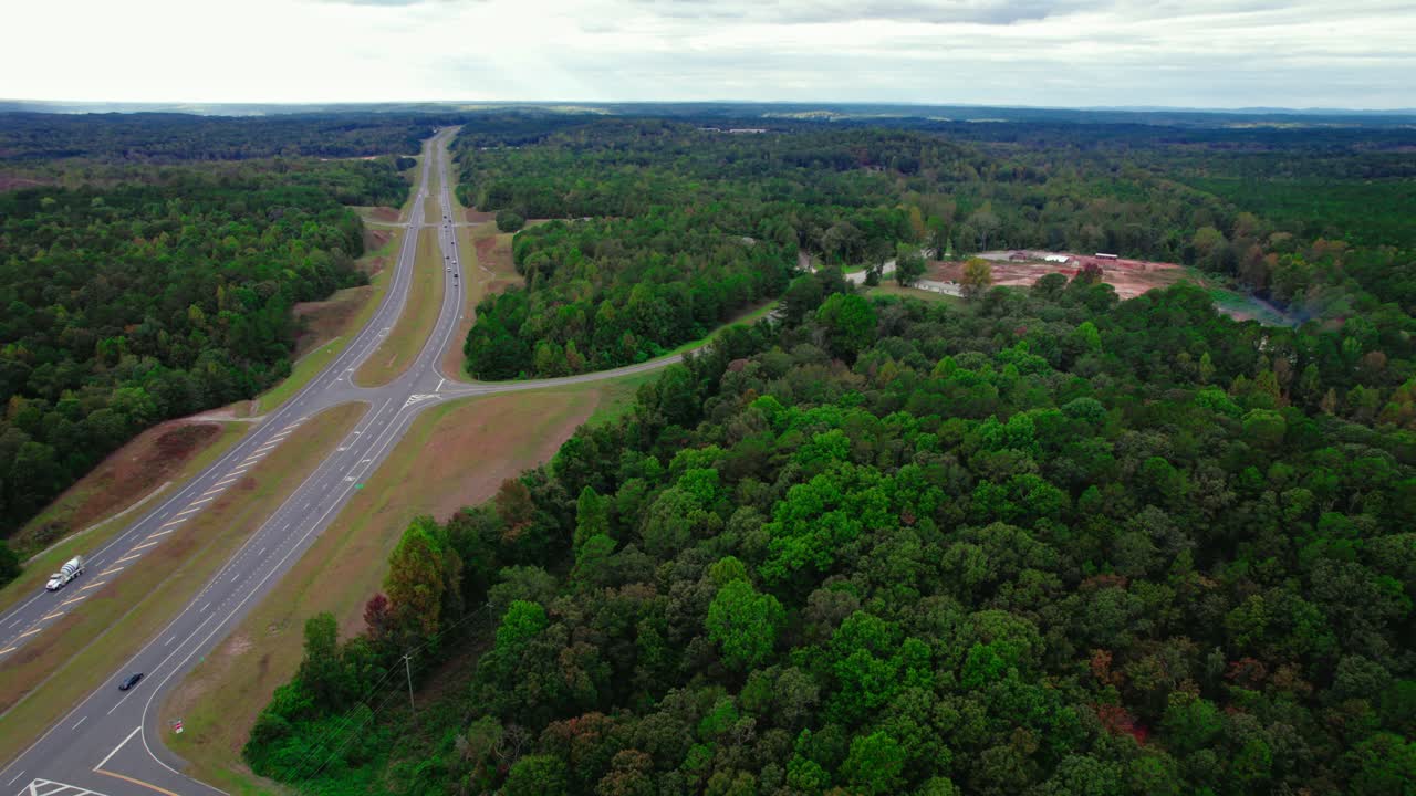 autopista en el medio de la naturaleza muy saturado vivos colores pop árboles circundantes camino lateral a un edificio sitio demolido coches que pasan por aves viajeras vista de transporte en el bosque brent alabama