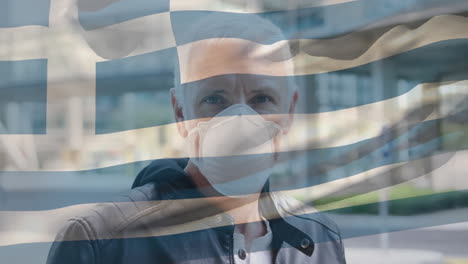 greece waving flag against portrait of caucasian senior man wearing face mask on the street