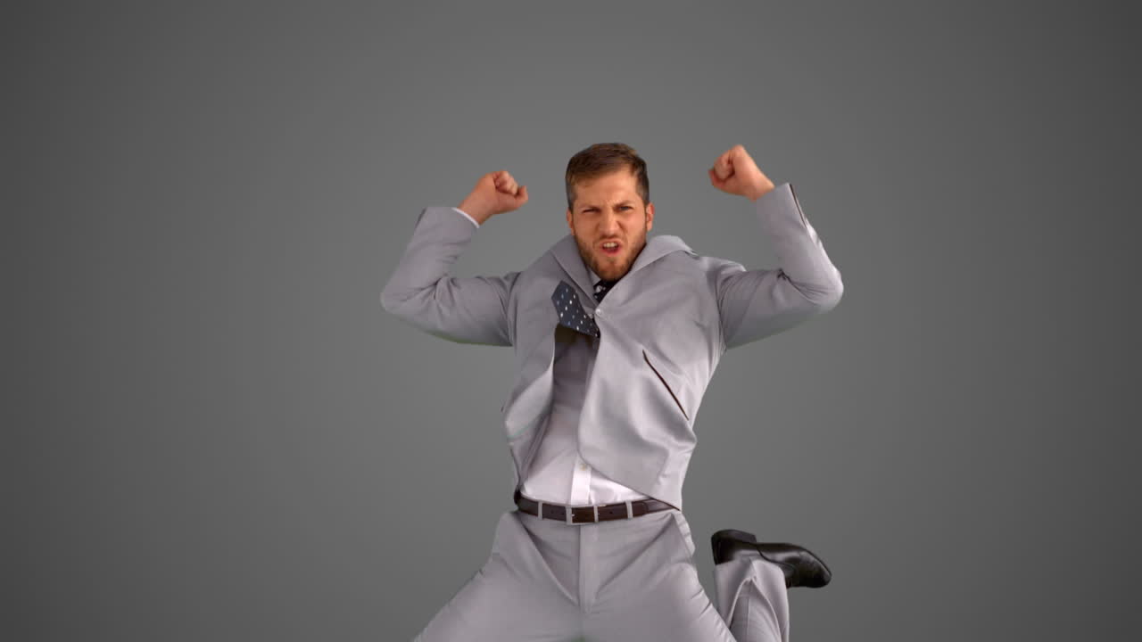 성공한 사업가가 회색 배경에 뛰어다니고