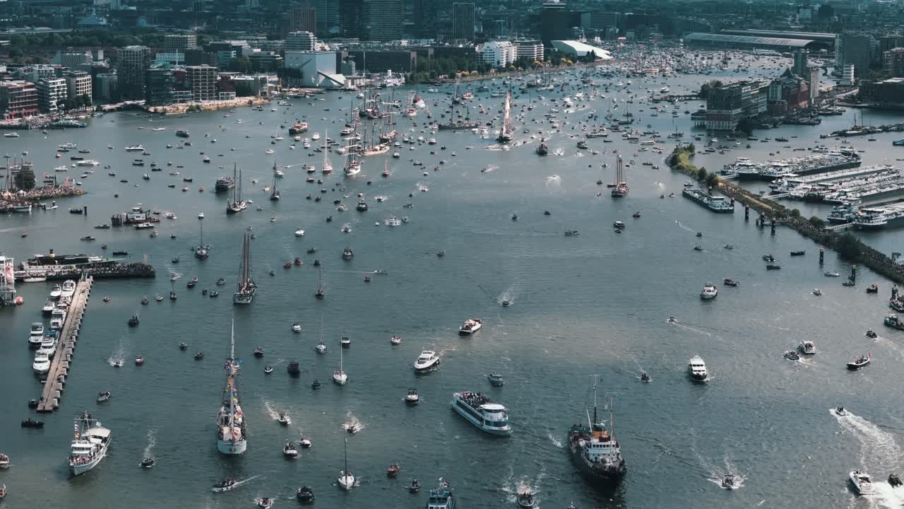 Giant shadows drift across the river as thousands of boats fill the frame