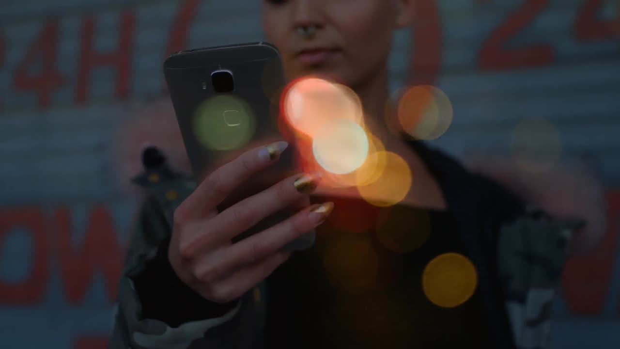 mujer usando un teléfono móvil rodeada por el efecto bokeh