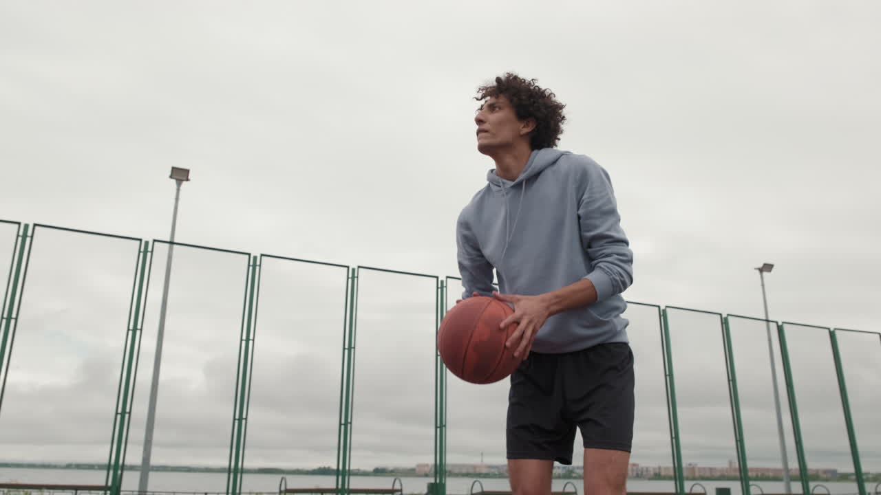 A man playing basketball on an outdoor court