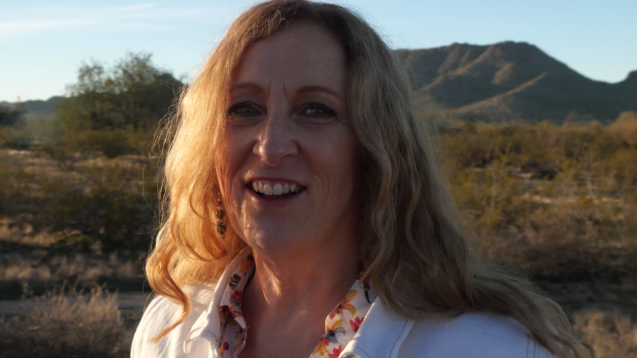 mulher tendo bate-papo por vídeo usando smartphone ao ar livre compartilhando aventura de viagem panorâmica montanhas de fundo, câmera lenta