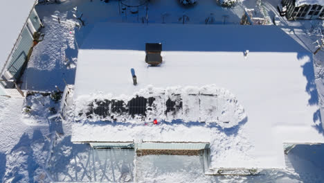 Aerial-view-rising-away-from-partly-snowy-PV-cells-on-a-house-roof