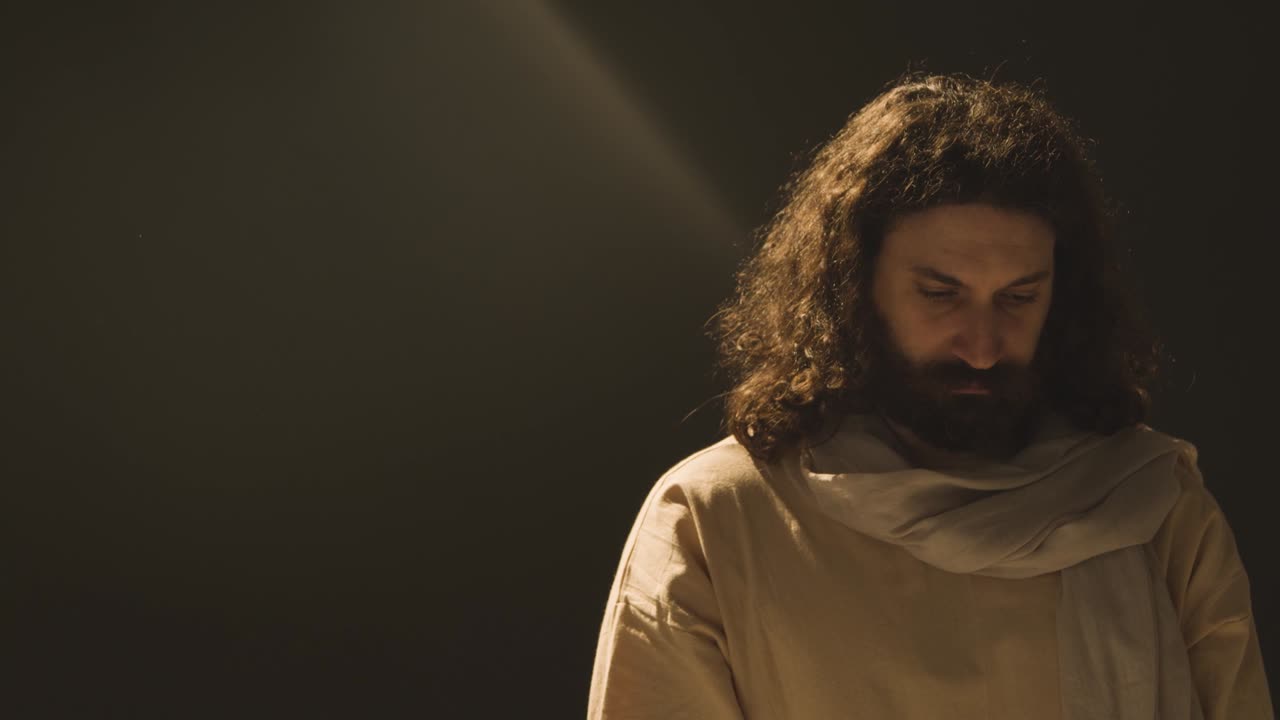 retrato de un hombre vestido con túnicas con cabello largo y barba que representa la figura de jesucristo de pie piscina de luz