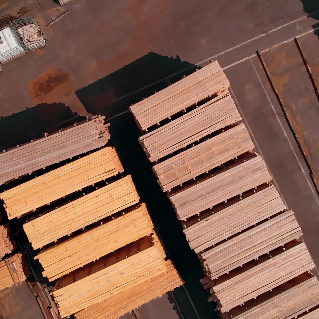 Lumber materials outdoods in the sun. Piles of wooden planks at the territory of modern door producing company