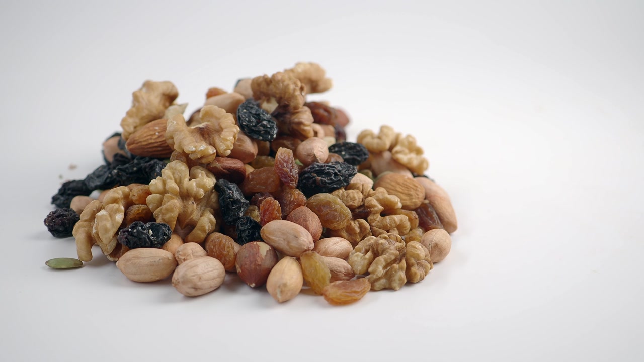 Pile of Mixed Nuts and Dried Fruits on White Background