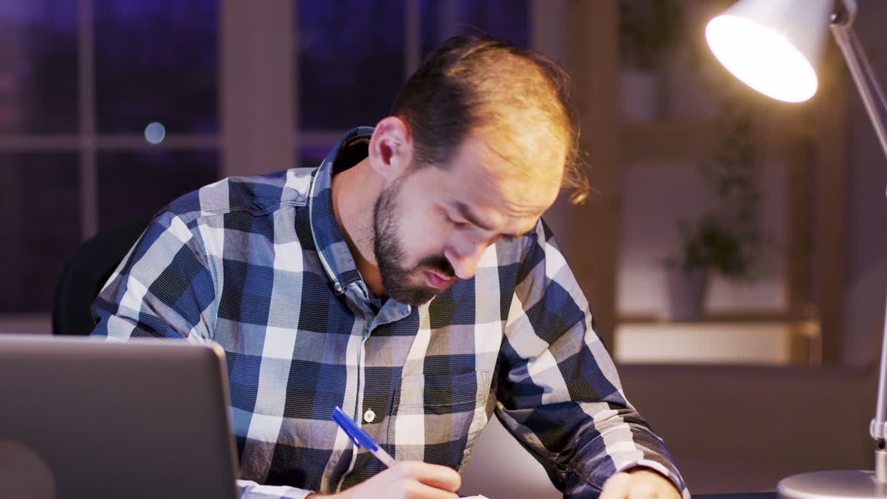 Man working at desk with laptop and documents
