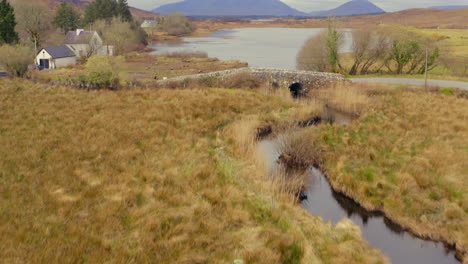 river to mountains: aerial reveal of quiet man bridge and connemara landscape