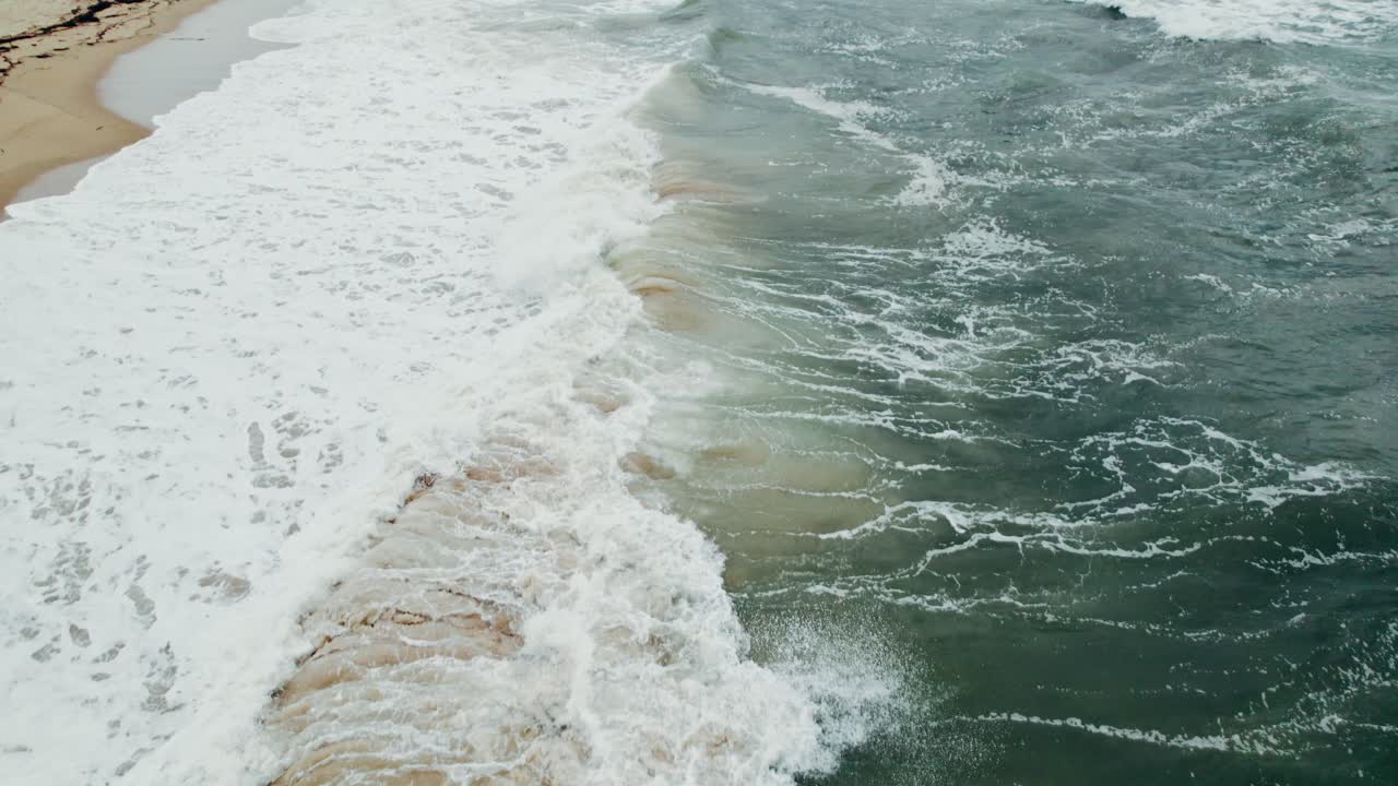 olas rompiendo en una playa de arena