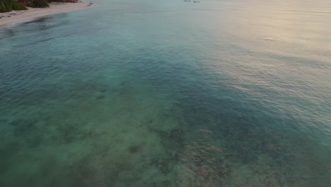 Aerial-Flyover-Turquoise-Shallow-Ocean-Water-by-Beach