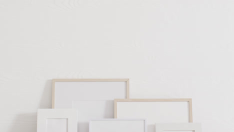 wooden and white frames with copy space on white background and white wall