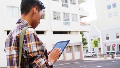 A-man-walking-and-using-a-tablet-computer-