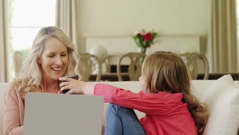 Mutter-Und-Tochter-Benutzen-Mobiltelefon-Im-Wohnzimmer