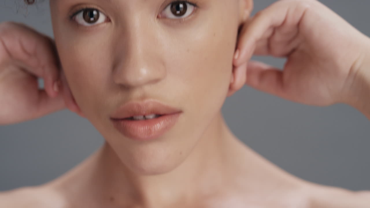 가까운 아름다움 초상화 매력적인 젊은 여성 손으로 얼굴을 만지며 애정하는 건강한 완벽한 피부 피부색은 회색 배경에서 자연스러운 피부 관리를 즐긴다
