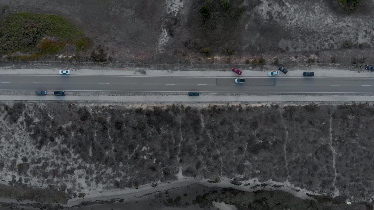 양쪽에 모래와 덤불이 있는 자연 보호 구역의 도로 수직