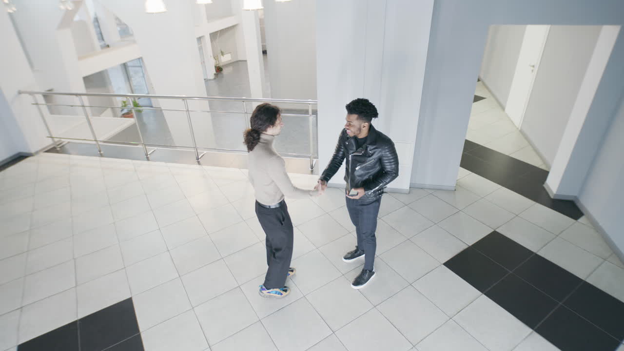 Men meet and talk in a bright modern office lobby