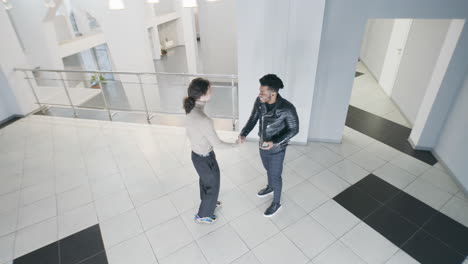 men meet and talk in a bright modern office lobby