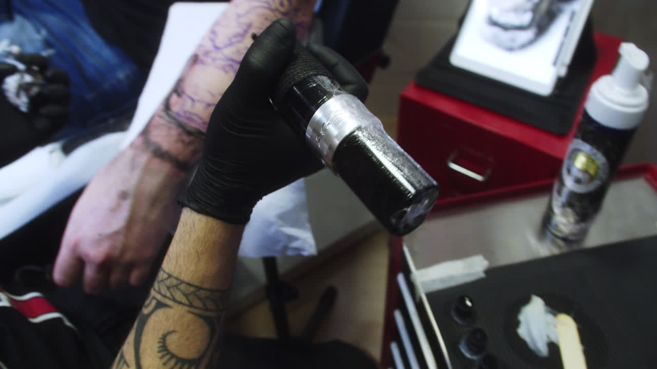 Professional tattoo artist refills his wireless tattoo machine