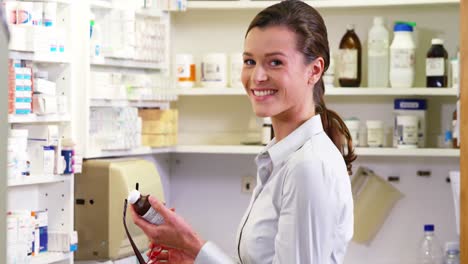 pharmacist checking a bottle of drug in pharmacy