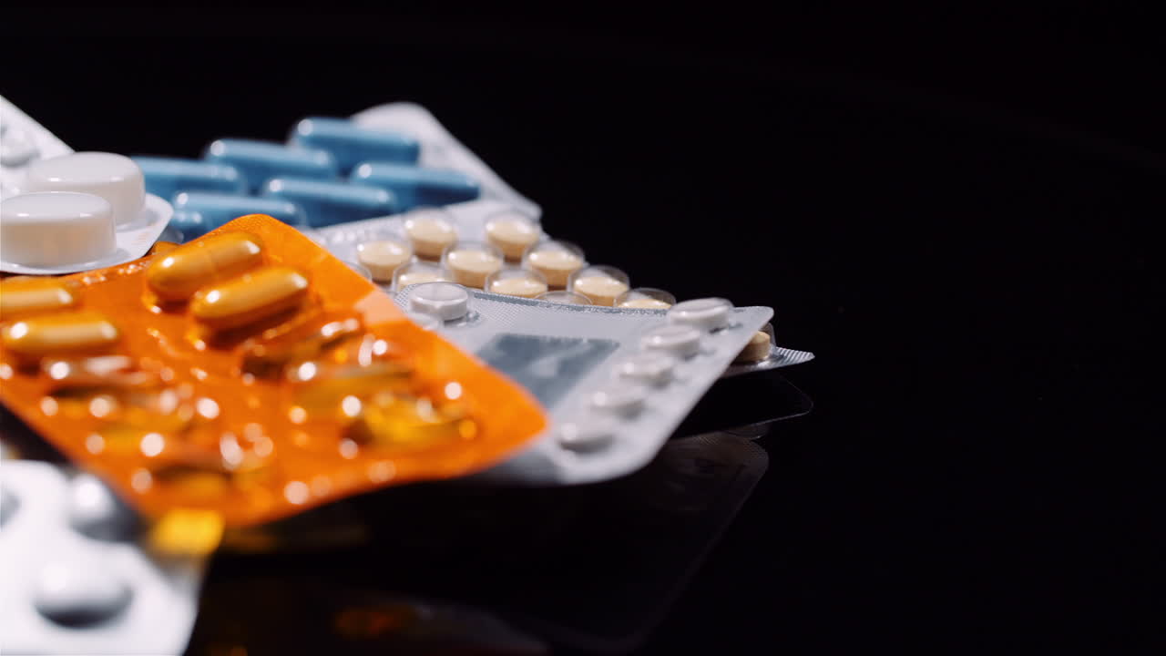 varias píldoras médicas drogas fondo negro industria farmacéutica analgésicos rotación 10