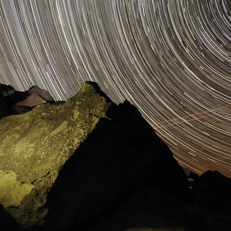 Time lapse star trail streaks over a sacred Owens Valley Paiute petroglyph site in the Eastern Sierras California