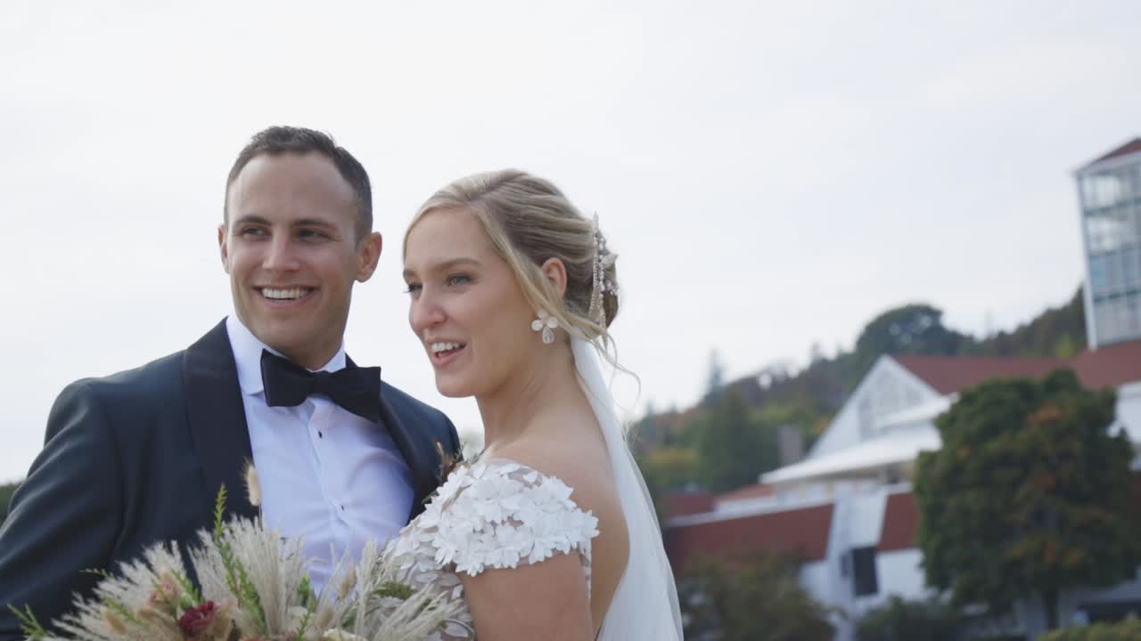 Bride and groom laugh together in front of beautiful building