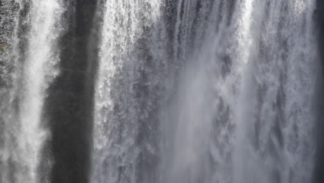 cerca del agua cayendo sobre una gran cascada de islandia en cámara lenta