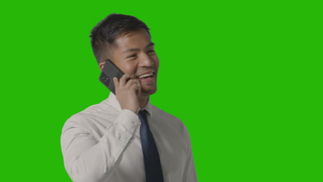 Studio-Shot-Of-Smiling-Businessman-In-Suit-Talking-On-Mobile-Phone-Against-Green-Screen-1